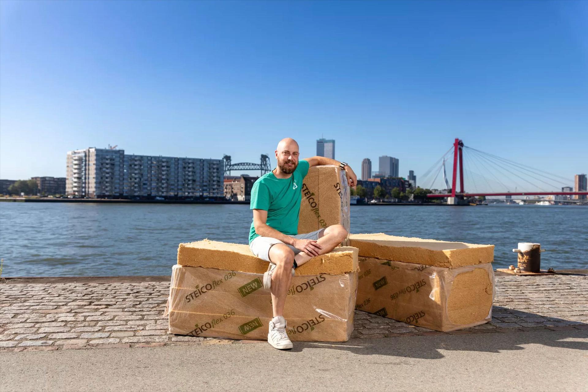 Portret van Joost van der Waal. Hij zit aan het water in Rotterdam op zijn matten van ecologisch isolatiemateriaal.